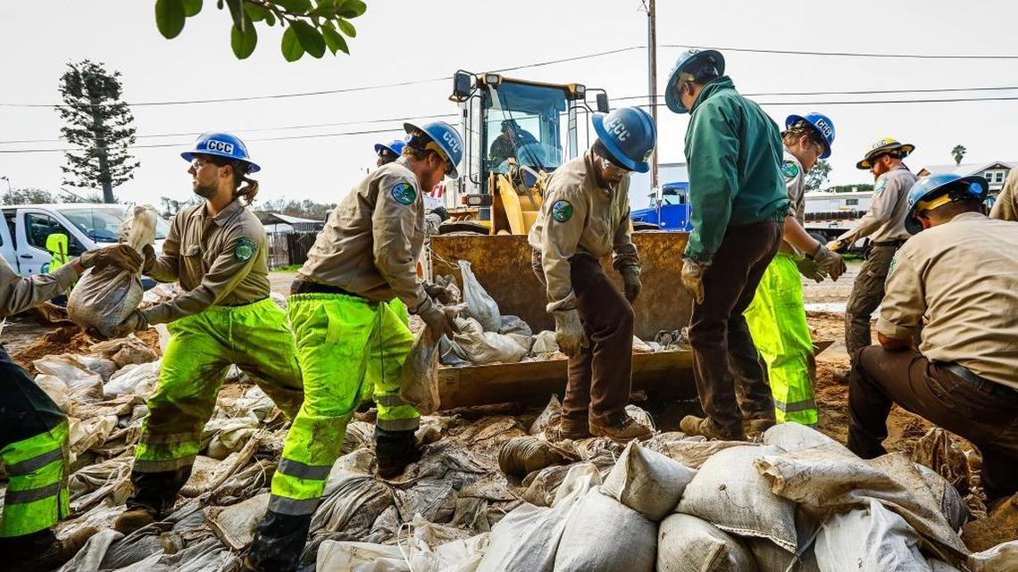 A California Conservation Corps crew from the San Luis Obispo Los Padres Center works on filling 14,000 sand bags to help protect a levee along the bank of the Arroyo Grande Creek in Oceano.