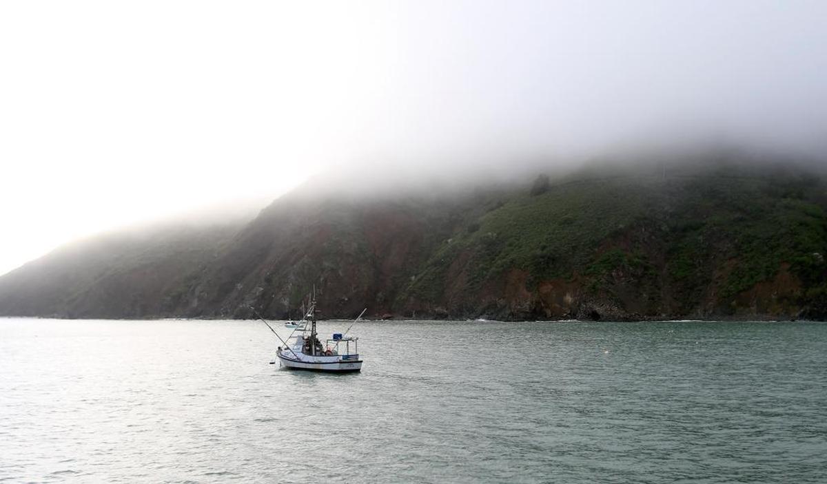 A calm in the rainy weather made for some pretty scenes in Avila Beach on Friday. Here, low clouds hang over the hills in a view from Harford Pier.