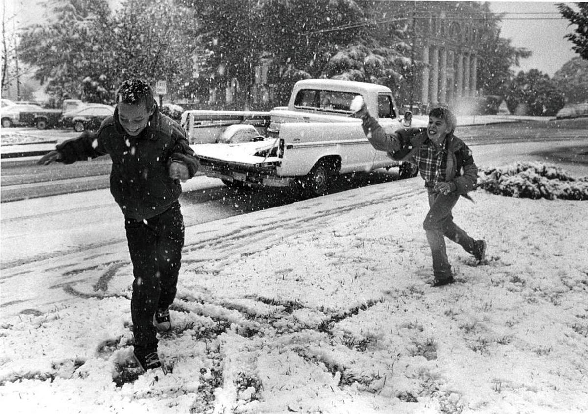 Dallas Parish, left, and Brett Fay, both 10, throw snowballs near Atascadero’s historic administration building after snow fell in December 1988.