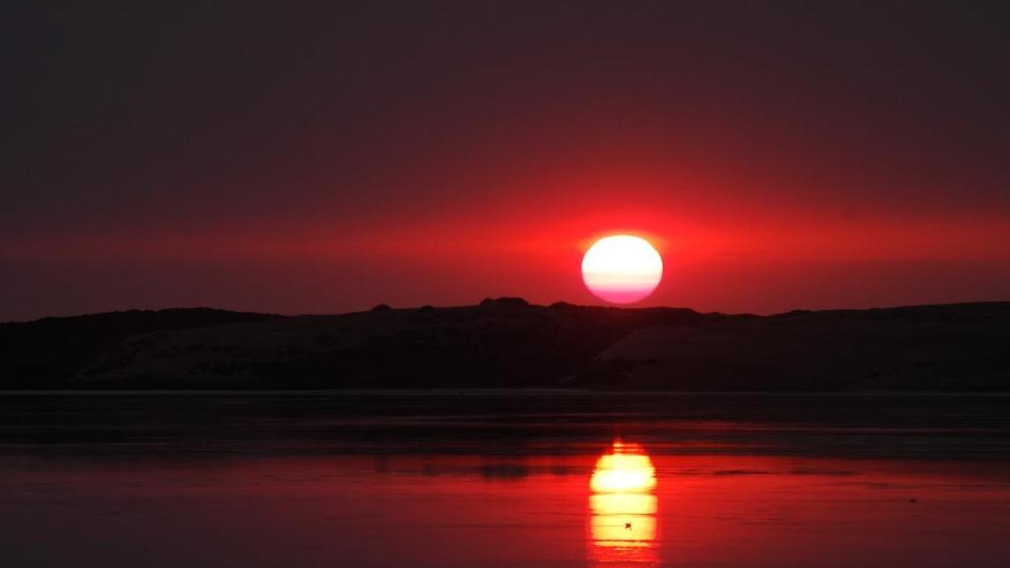 The sun over Morro Bay, as seen from Baywood Park.