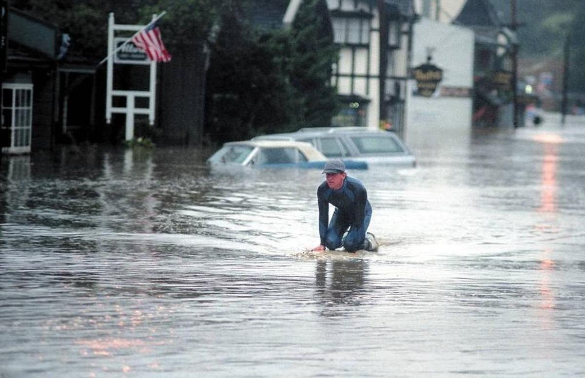 A surfboard was the preferred vehicle for getting around Main Street in the West Village of Cambria on March 10, 1995, when heavy rains and high tides combined to flood the town with the waters of Santa Rosa Creek.