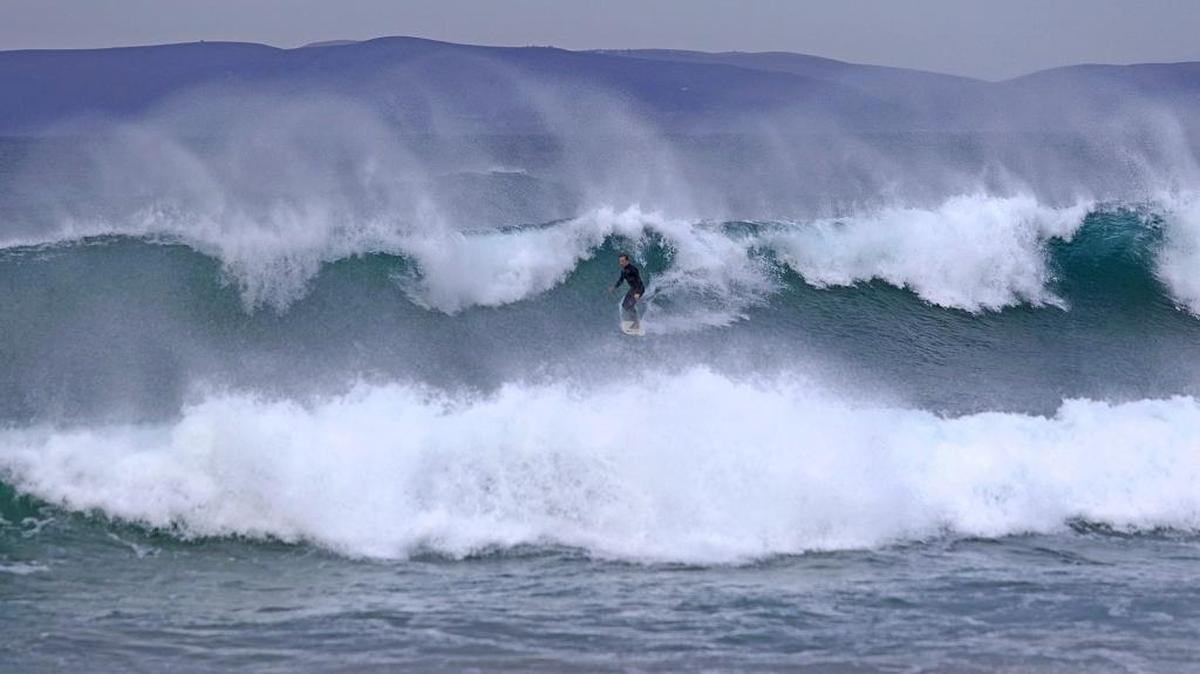 Afternoon offshore winds created wind spray on the edges of large waves in Morro Bay near Morro Rock in 2016.