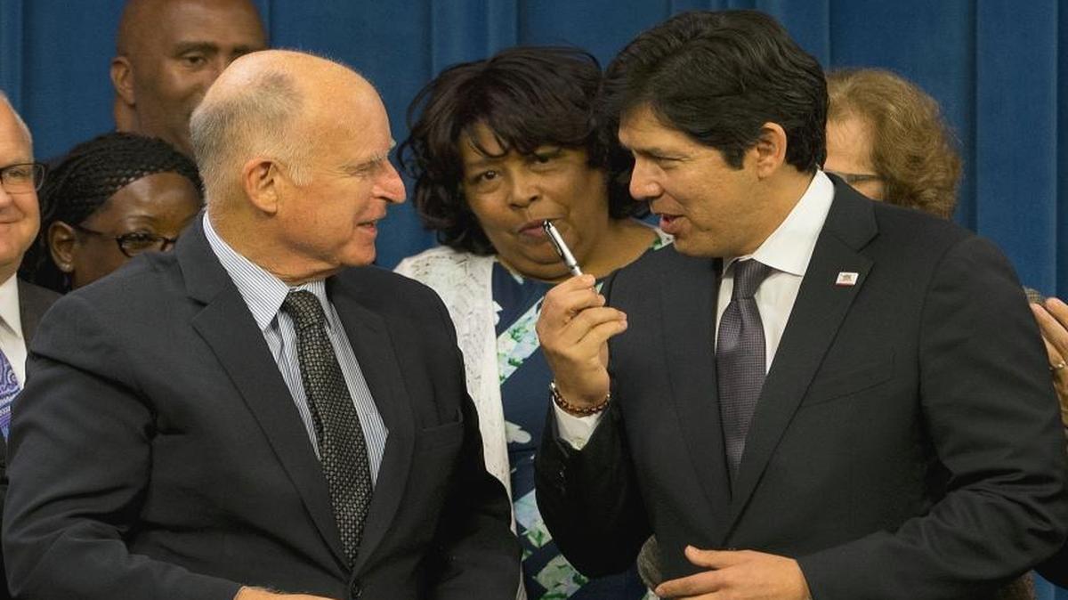Senate President Pro Tem Kevin de León, D-Los Angeles, right, thanks Gov. Jerry Brown after Brown gave de León the pen used to sign legislation to automatically enroll millions of private-sector workers in retirement saving accounts in September. The law is now under attack by congressional Republicans.