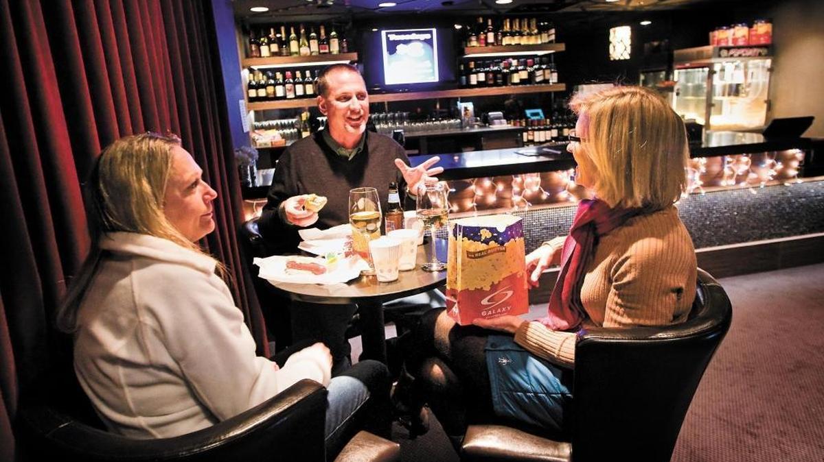 Melanie Lighfoot, left, her husband Ashley of Atascadero and their friend Anita Pedersen of Colorado enjoy some wine, beer and snacks at Galaxy in Atascadero. It was the first movie theater in the county to sell beer and wine. Now Regal theater in Arroyo Grande is seeking city permission to sell alcohol.