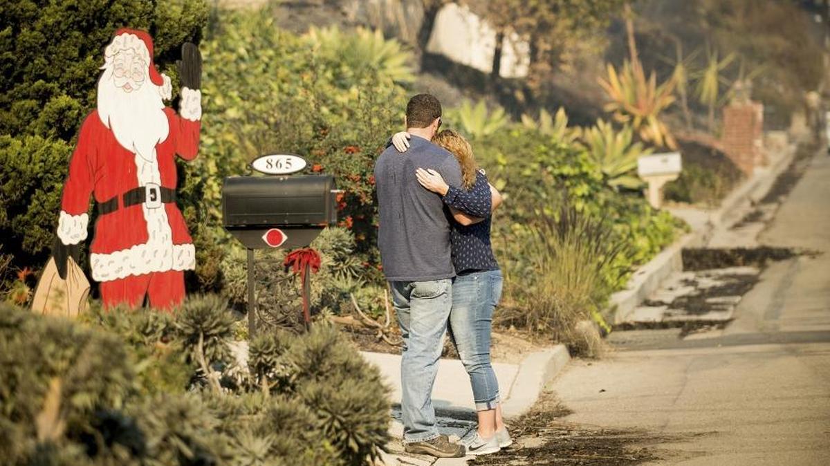 Paul and Erica Mattesich embrace before sifting through rubble at their Ventura. The family lost their house when the Thomas fire tore through their neighborhood on Colina Vista.