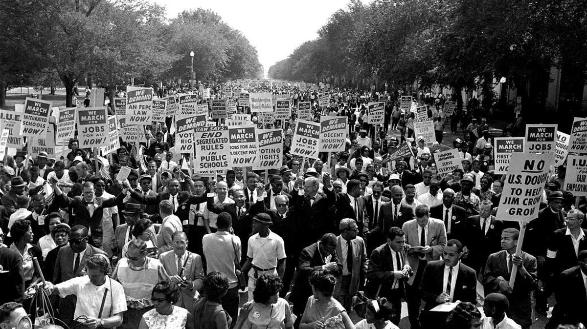 The Rev. Martin Luther King Jr., center left with arms raised, marches along Constitution Avenue on Aug. 28, 1963, with other civil rights protestors carrying placards, from the Washington Monument to the Lincoln Memorial during the March on Washington.