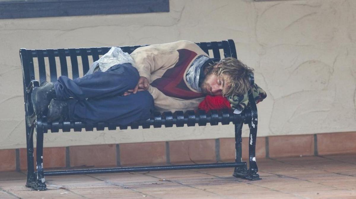 Brandon Michael Williams keeps a wary eye open as he gets some rest and shelter from the rain at the train station in Grover Beach in January.