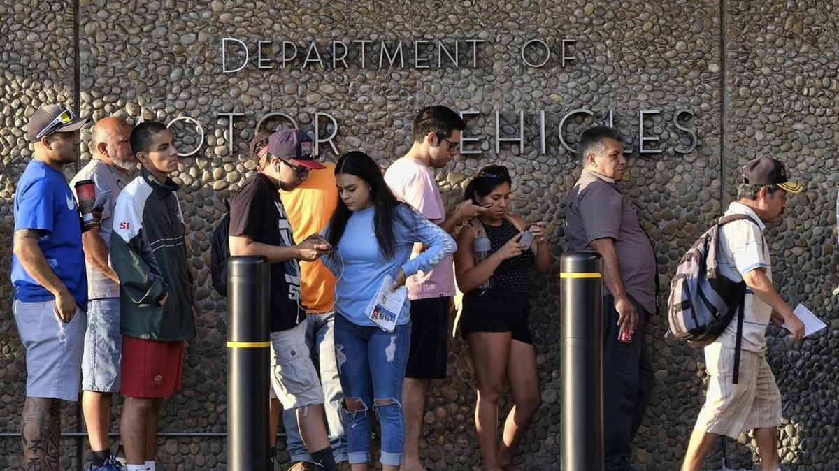 FILE - In this Aug. 7, 2018, file photo, people line up at the California Department of Motor Vehicles prior to opening in the Van Nuys section of Los Angeles. An audit issued by California Department of Finance and released on Wednesday, March 27, 2019, say the DMV didn’t properly prepare for customers seeking to get new federally approved drivers’ licenses, leading to hours-long wait times. (AP Photo/Richard Vogel, File)