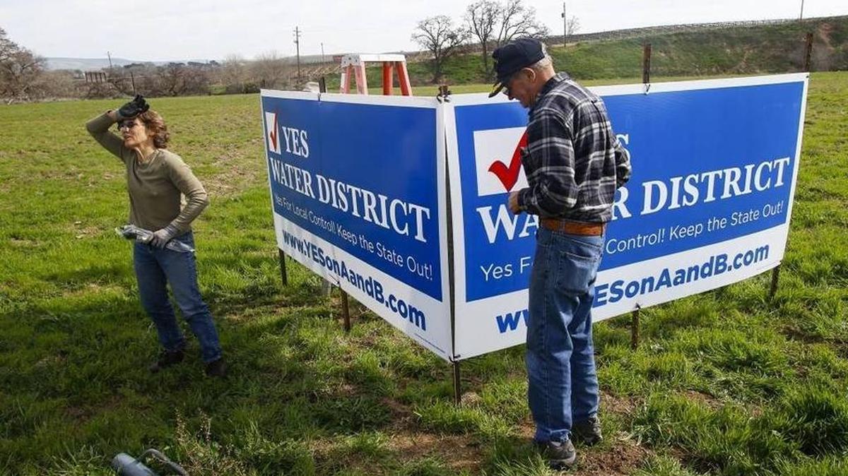 Laurie Gage and Dave King install signs supporting the creation of a groundwater basin district on San Marcos Road between Paso Robles and San Miguel.