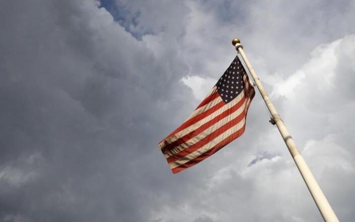 An American flag flaps in the wind as storm clouds build over the main post office earlier this month in Denver.
