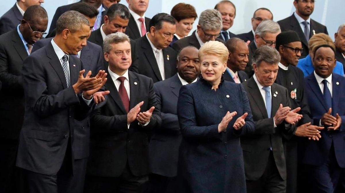 U.S. President Barack Obama, left, and Brazil's President Dilma Rousseff, front row third from right, applaud as they pose with world leaders for a group photo at the COP21, United Nations Climate Change Conference, in Le Bourget, outside Paris, Monday, Nov. 30, 2015.