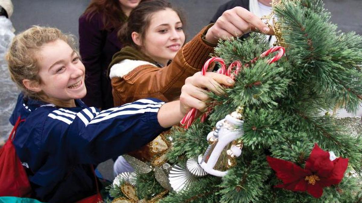 Volunteers for United Way of SLO County gets a Christmas tree ready for a needy family in Paso Robles in 2010.