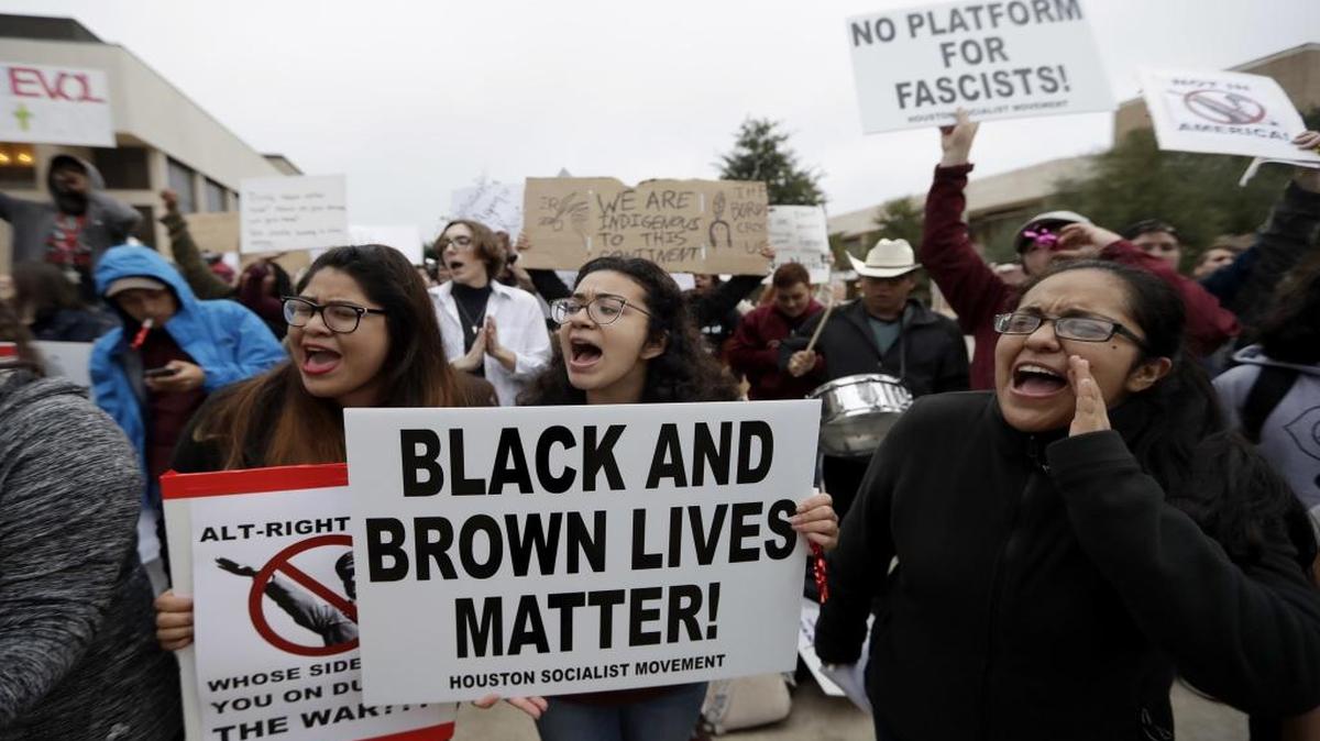 Demonstrators hold signs as they chant outside the venue where Richard Spencer, who leads a movement that mixes racism, white nationalism and populism, is scheduled to speak at Texas A&M University, Tuesday, Dec. 6, 2016, in College Station, Texas.