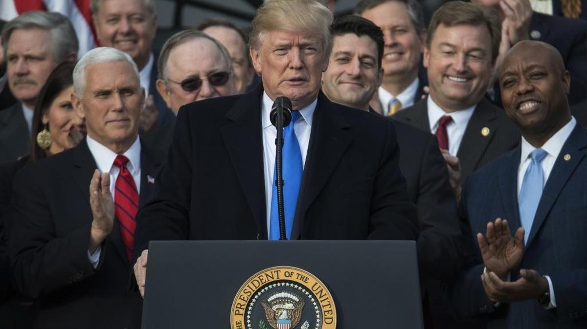 In this Dec. 20, 2017, photo, President Donald Trump, joined by Vice President Mike Pence, Speaker of the House Paul Ryan, R-Wis., and other members of Congress, pauses as he speaks during an event on the South Lawn of the White House in Washington, to acknowledge the final passage of tax overhaul legislation by Congress.