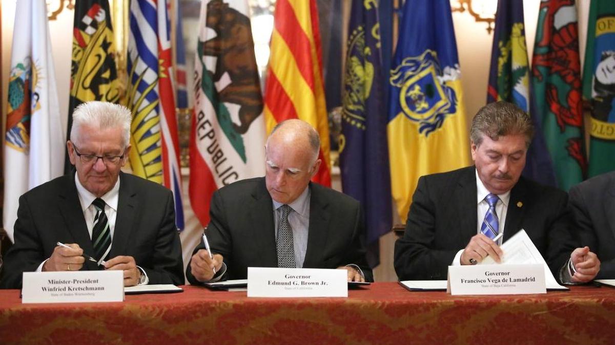 Gov. Jerry Brown, center, flanked by Baden-Wurttemberg Minister-President Winfried Kretschmann, left, of Germany, and Baja California Gov. Francisco A. Vega de Lamadrid, join others in signing a non-binding climate change agreement in Sacramento, Calif.