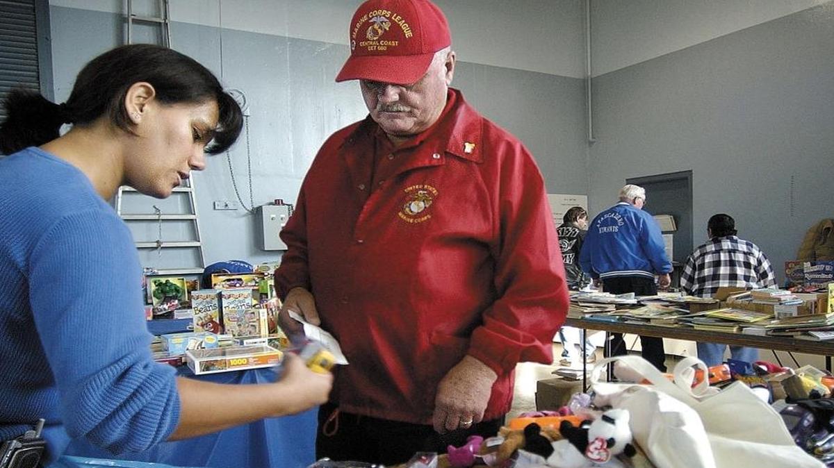 Angelica Castaneda picks out some gifts for her children with some help from Russ Tolchard at the Loaves and Fishes charity located at the National Guard Armory in Atascadero in 2004.