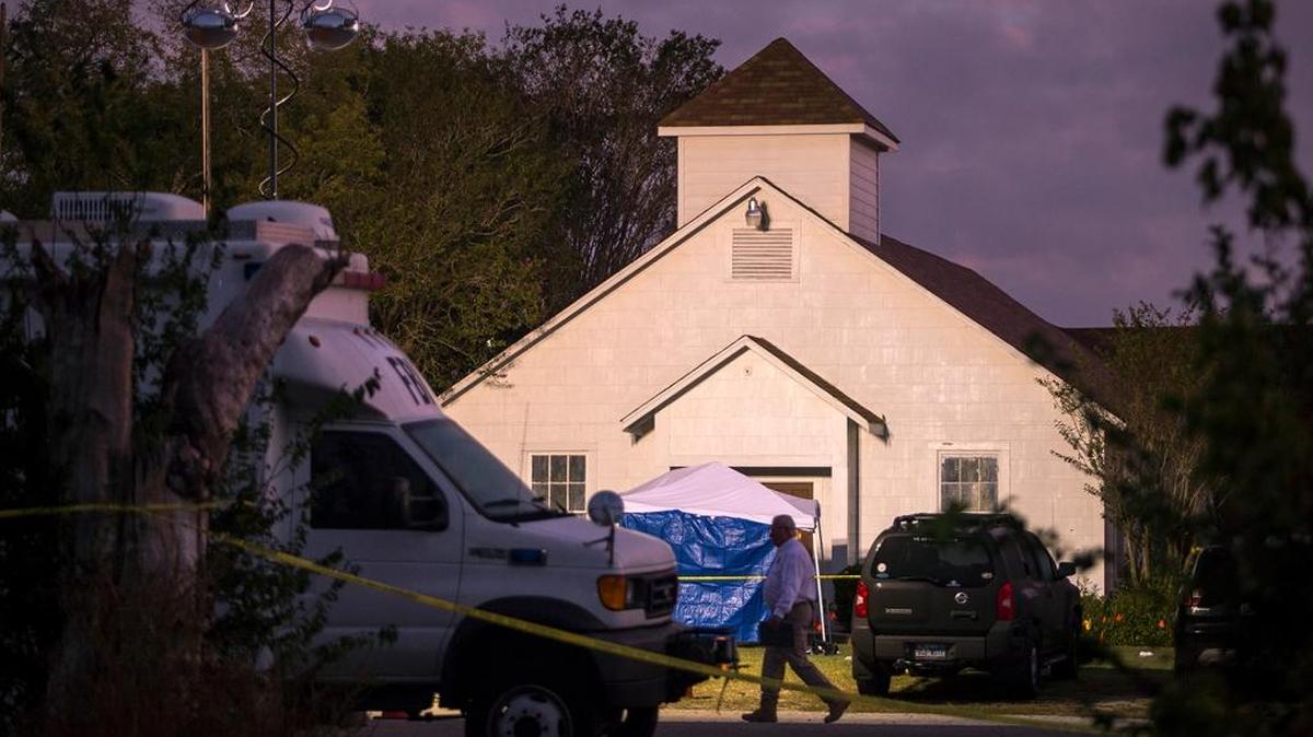 A man walks past the front of the First Baptist Church where a gunman opened fire on a Sunday service and killed at least 26 people in Sutherland Springs, Texas on Monday, Nov. 6, 2017.