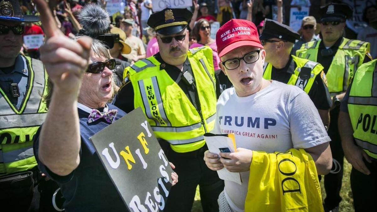 Trump protestor Susan O'Lone of Norwich, Conn., left, debates numerous topics with Trump supporter Brian Pryor of East Hartford including climate change, Russia and the firing of FBI Director James Comey in McKinley Park while President Donald J. Trump delivered the keynote address at the U.S. Coast Guard Academy's 136th commencement in New London, Conn., Wednesday, May 17, 2017.