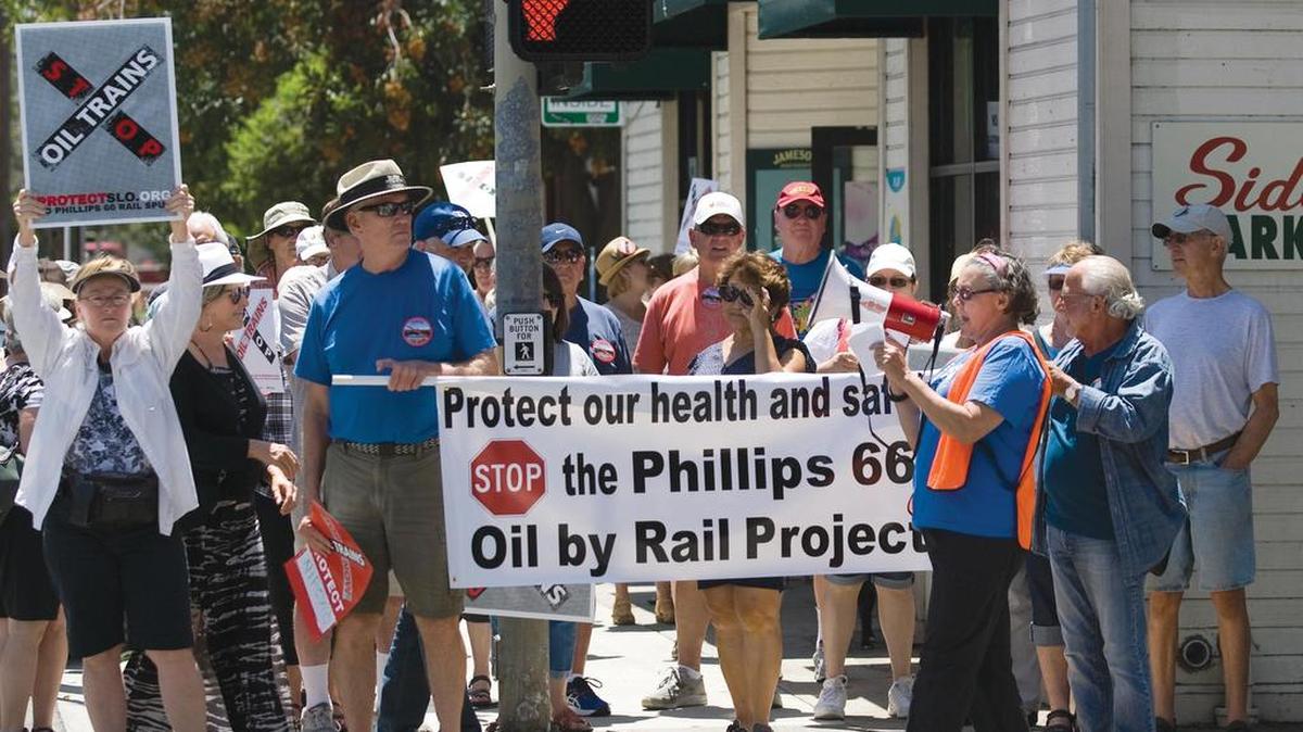 A large group met at Mitchell Park in San Luis Obispo on Saturday, July 9, 2016, to protest the Phillips 66 oil train proposed to travel through Santa Barbara and San Luis Obispo counties. The group left Mitchell Park and marched through town to the SLO County administration building on Monterey Street. San Luis Obispo Mayor Jan Marx, Santa Barbara County Supervisor Salud Carbajal and Charles Varney, representative of the San Luis Obispo Surfrider’s Association were among some of the key speakers. Several hundred protestors walk up Osos Street toward the County Building on Monterey Street. Maureen Forney, a teacher from San Leandro, spurs on the crowd to chant.