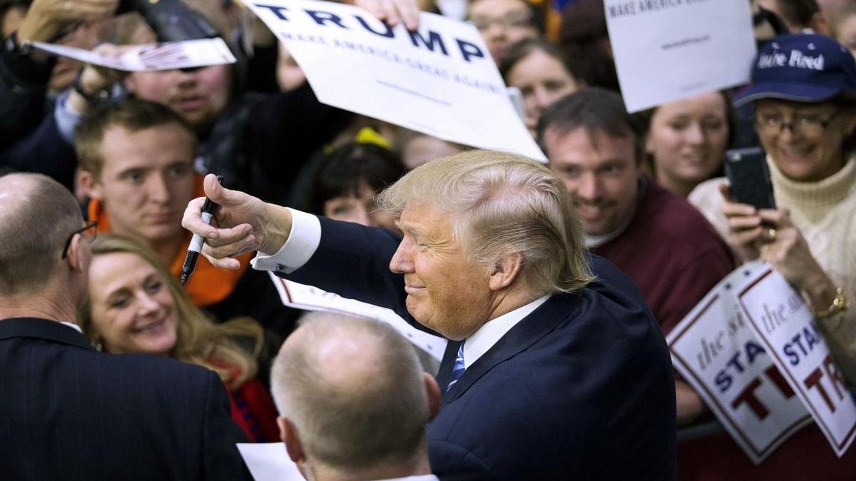 Republican presidential candidate Donald Trump gestures to the crowd as he signs autographs during a campaign event at Plymouth State University in Plymouth, N.H.
