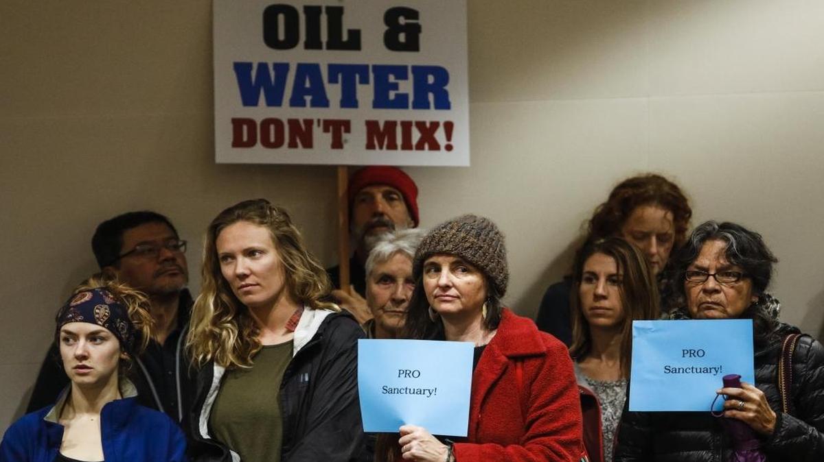 Supporters of the Chumash Heritage National Marine Sanctuary hold signs during the San Luis Obispo County Board of Supervisors meeting on Feb. 7, 2017.