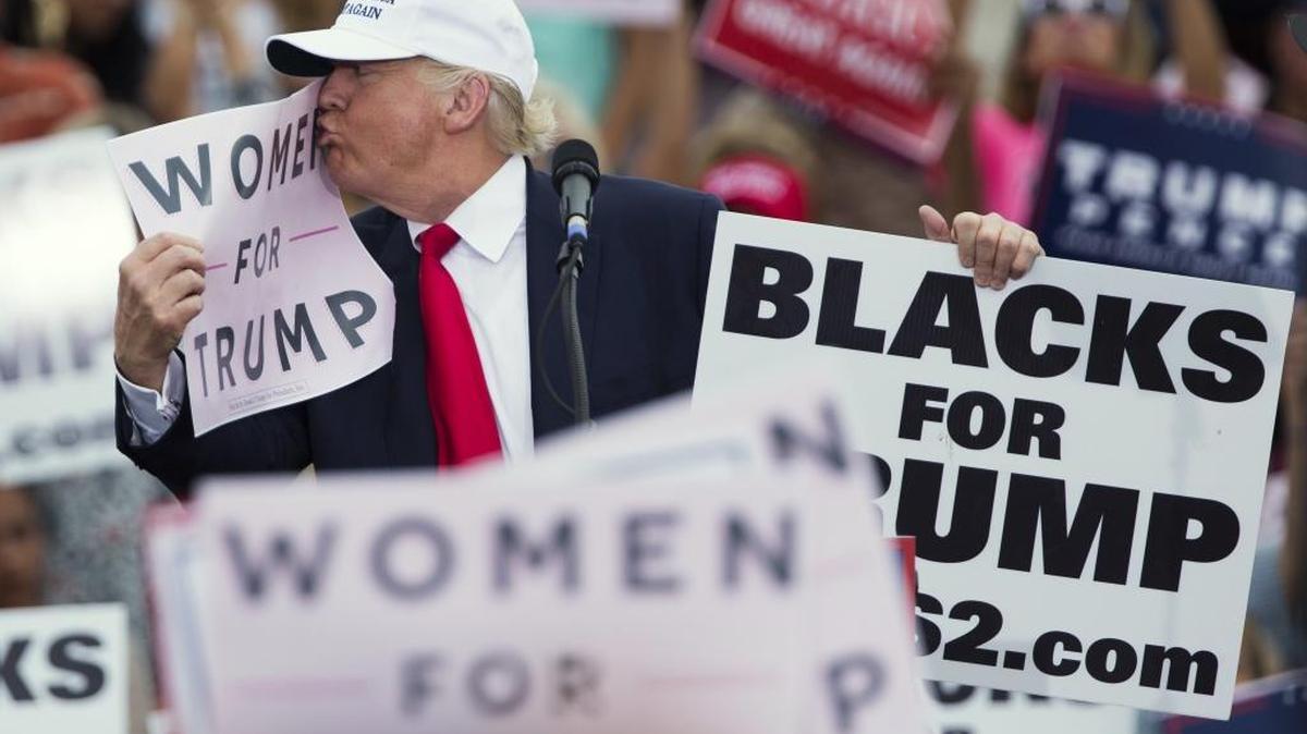 Republican presidential candidate Donald Trump kisses a “Women for Trump” sign during a campaign rally on Wednesday, Oct. 12, 2016, in Lakeland, Fla.