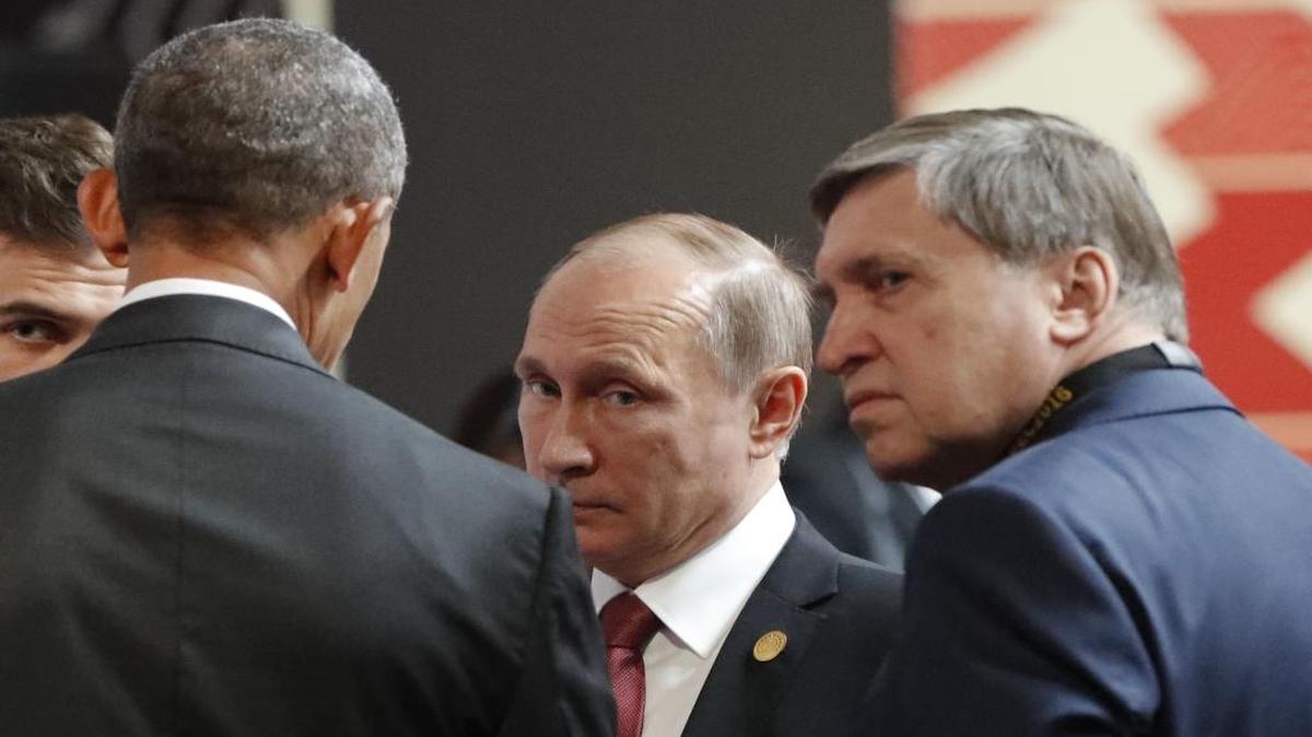 In this Nov. 20, 2016, photo, U.S. President Barack Obama, left, talks with Russia's President Vladimir Putin, center, and Kremlin foreign affairs adviser Yuri Ushakov at the opening session of the Asia-Pacific Economic Cooperation (APEC) in Lima, Peru.