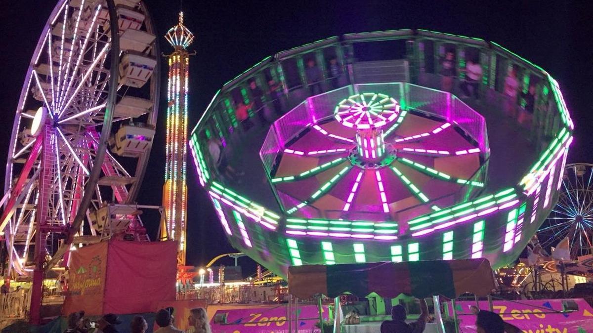 Mid-State Fair rides illuminate the carnival area.
