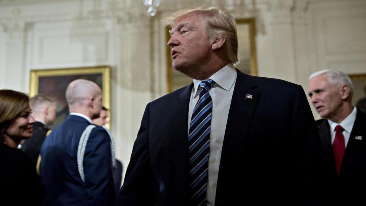 President Donald Trump walks out with U.S. Vice President Mike Pence (right), during a swearing in ceremony of White House senior staff in the East Room of the White House in Washington on Jan. 22, 2017.