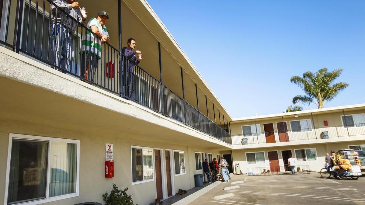 After a day of work, guest workers socialize at their housing, an old converted Budget Inn in Santa Maria.
