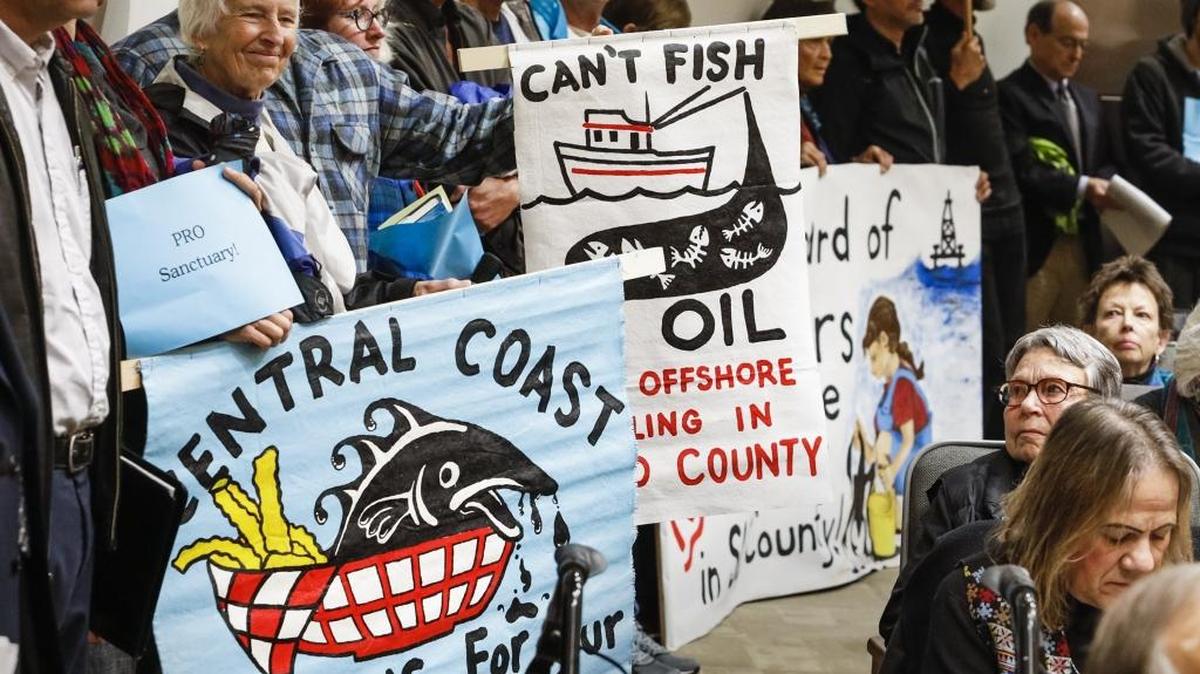 Supporters of the Chumash Heritage National Marine Sanctuary holds signs during the Board of Supervisors meeting Feb. 7, 2017.