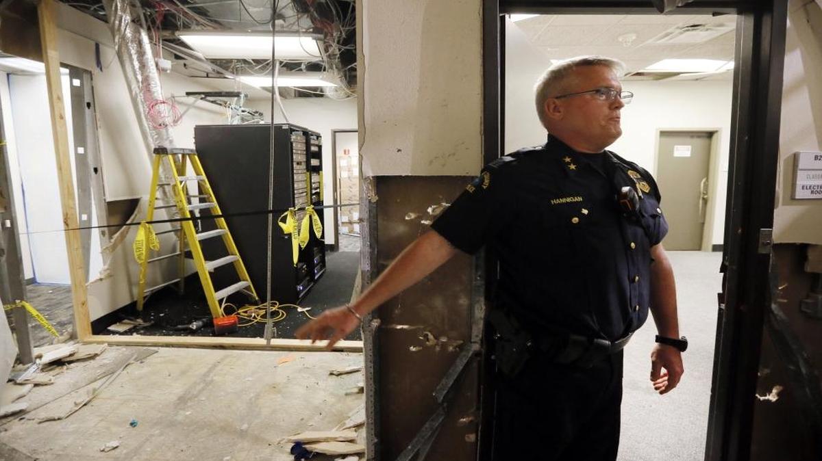 El Centro College police Chief Joseph Hannigan stands at the end of a hallway as he gives a guided tour of the damage caused by a blast that killed Micah Johnson, Tuesday, July 19, 2016, in Dallas. Hannigan is pointing to the spot near a network server room where Johnson was killed by the blast.
