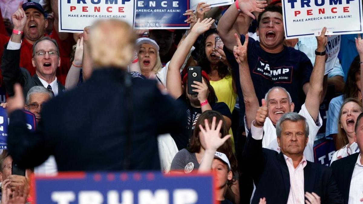 Republican presidential candidate Donald Trump waves to supporters during a campaign town hall in Daytona Beach, Fla.