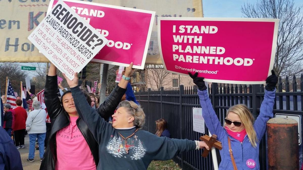 A Planned Parenthood supporter and opponent try to block each other’s signs during a protest and counter-protest on Feb. 11, 2017 in St. Louis.