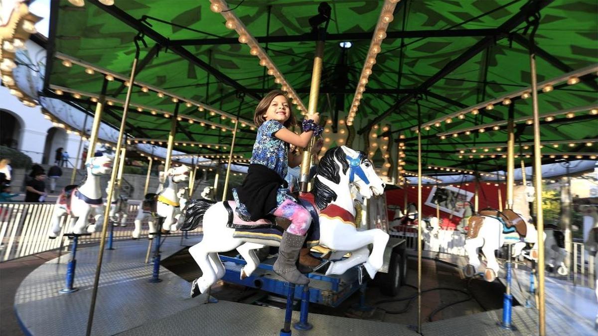 Kids were having fun riding the carousel in Mission Plaza Sunday, Dec. 4. On the horse is a smiling Charlotte Bailey, 6, of Paso Robles.