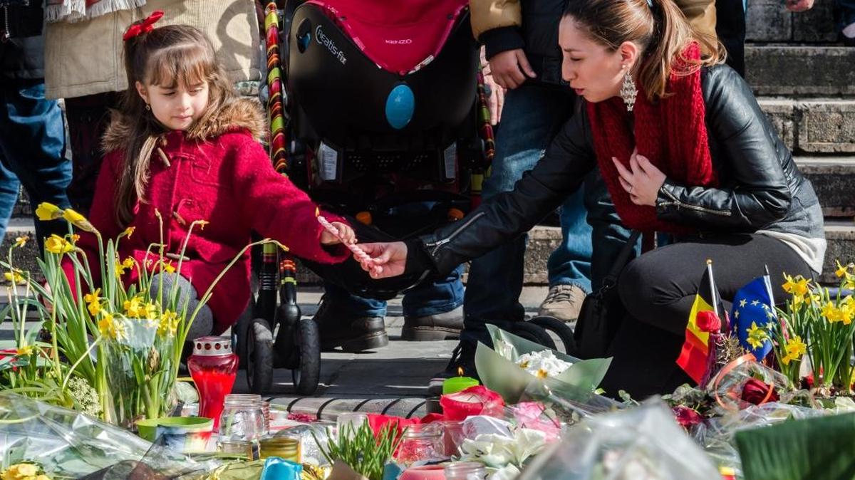 A woman and a girl light candles at tributes at a memorial site at the Place de la Bourse in Brussels on Saturday.