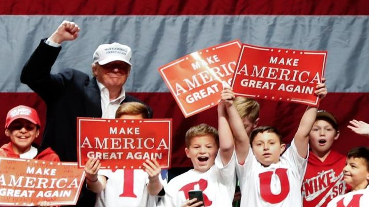 Republican presidential candidate Donald Trump poses with children on stage at a campaign rally in Sterling Heights, Mich., on Sunday.