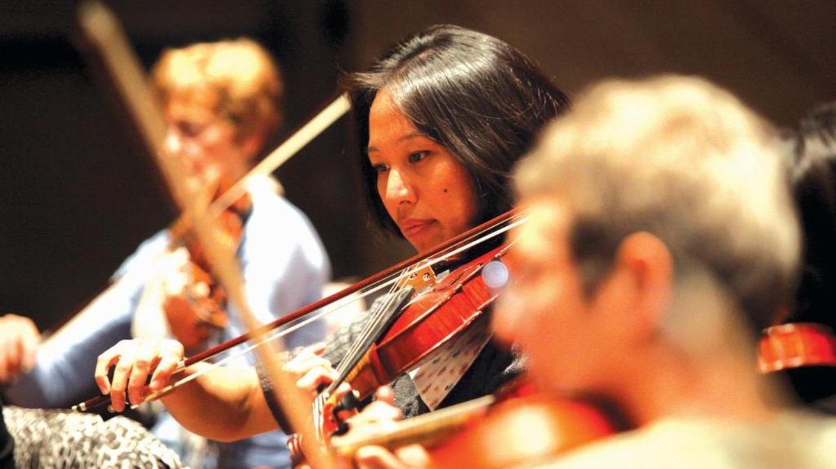 From left, violinists Sharon Holland, Grace Seng and Karen Loewi Jones of the San Luis Obispo Symphony practice at the Performing Art Center on Cal Poly’s campus in 2013.