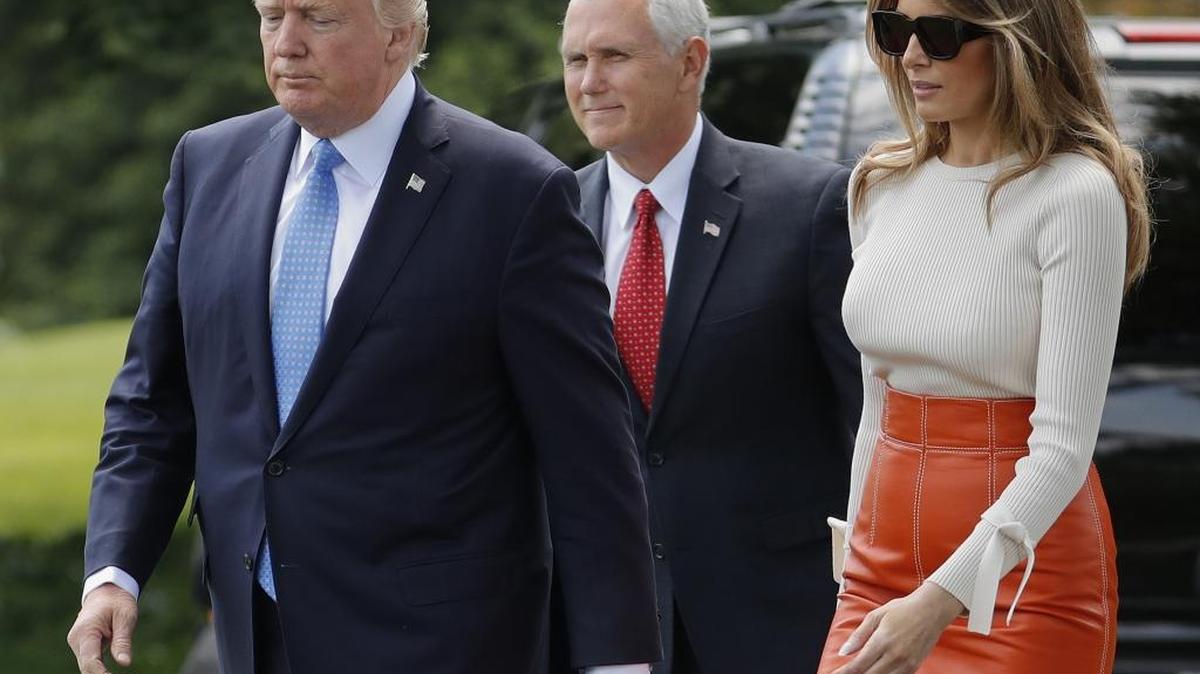 Vice President Mike Pence, center, watches as President Donald Trump and first lady Melania Trump walks across the South Lawn of the White House in Washington, Friday, May 19, 2017, before the president and first lady boarded Marine One for a short trip to Andrews Air Force Base, Md.