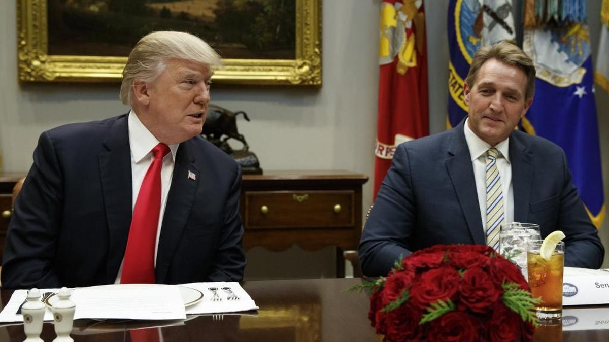 In this Dec. 5, 2017, file photo, Sen. Jeff Flake, R-Ariz., right, listens as President Donald Trump speaks before hosting a lunch with Senate Republicans in the Roosevelt Room of the White House in Washington.