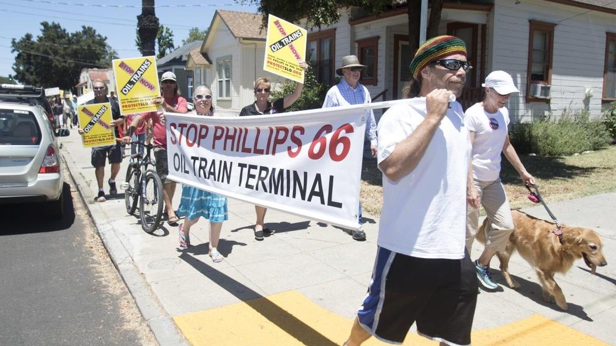 A protest against the approval of oil trains coming through San Luis Obispo County was held at Mitchell Park in San Luis Obispo, Saturday July 9, 2016. Protesters march with signs down Santa Barbara Street in San Luis Obispo toward the Amtrak train station.