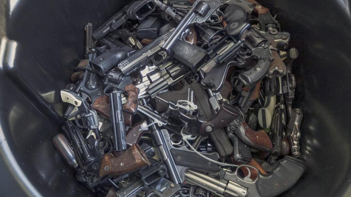 In this file photo, handguns fill up a trash can for recycling at the LA Memorial Sports Arena in Los Angeles.