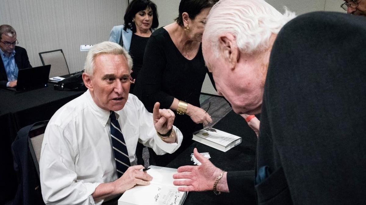 Roger J. Stone Jr., an advisor for President Donald J. Trump during the 2016 presidential campaign, signs a copy of his book, "The Making of the President 2016: How Donald Trump Orchestrated a Revolution", for Stanley Tate of Miami, right, during an event hosted by the conservative group America First inside the Marriott in Boca Raton, Fla., on Tuesday, March 21, 2017. Stone was the feature speaker who defended himself over contacts he had with Russia-linked hackers during the 2016 election.