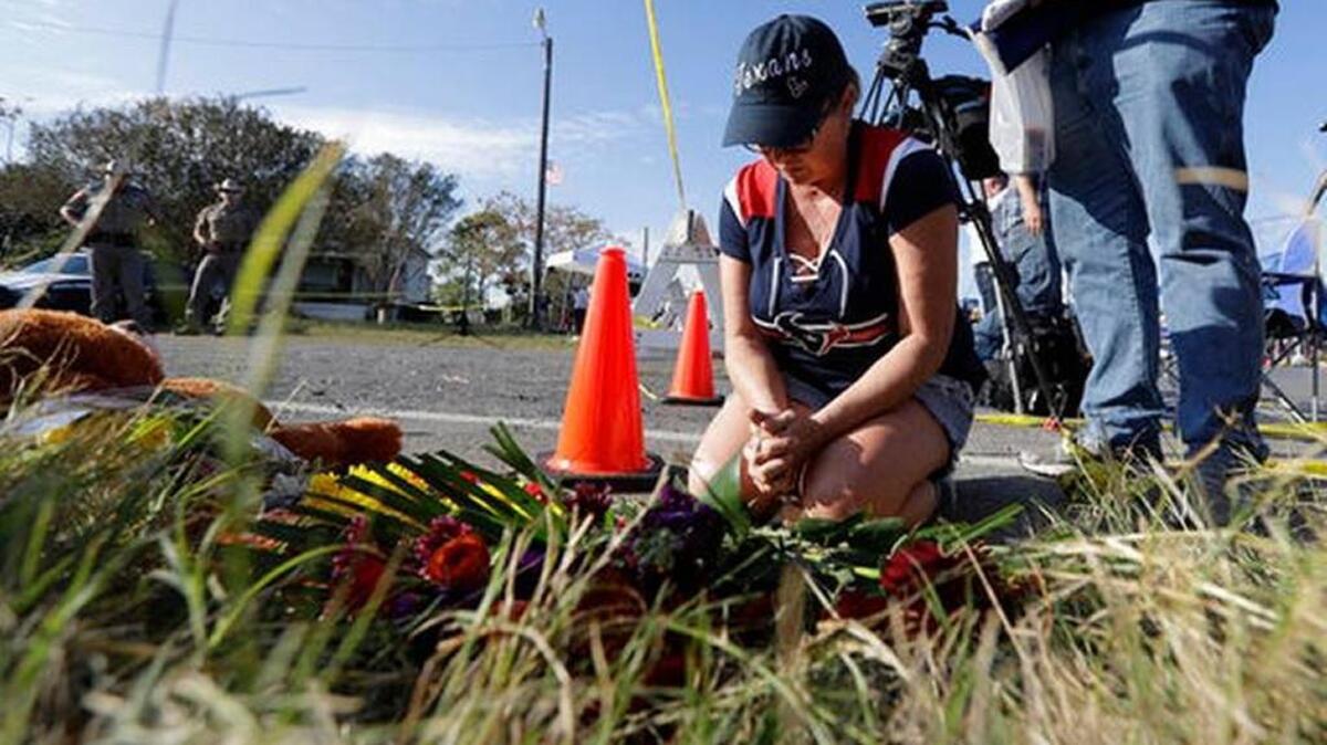 Rebecca Thompson prays at a makeshift memorial near the scene of a shooting at the First Baptist Church of Sutherland Springs to honor victims, Monday, Nov. 6, 2017, in Sutherland Springs, Texas. A man opened fire inside the church in the small South Texas community on Sunday, killing and wounding many.