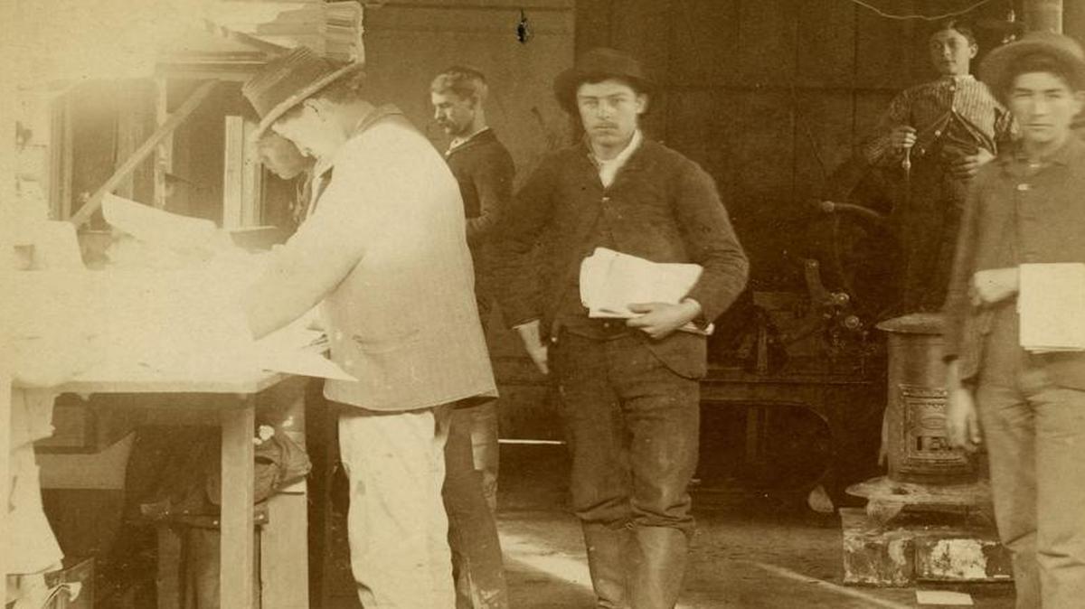 Benjamin Brooks was editor of the San Luis Obispo Morning Tribune for four decades. He is standing center in profile, back wall and appears to be final proofing at 4 a.m. for the morning paper. This is from a series of newspaper carrier postcards from 1890.