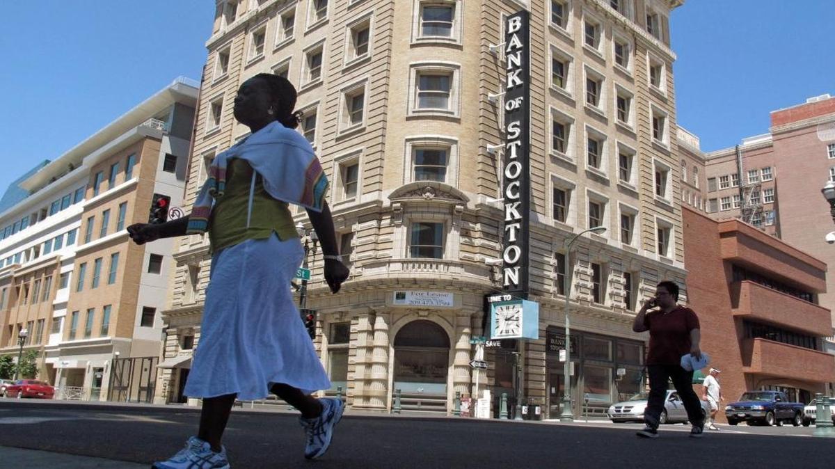 In this June 27, 2012, file photo, pedestrians cross a street near the Bank of Stockton in Stockton, Calif. In 2014, Stockton asked a U.S. Bankruptcy Judge to approve a plan for reorganizing more than $900 million in long-term debt over objections from a lone creditor who says it was treated unfairly.