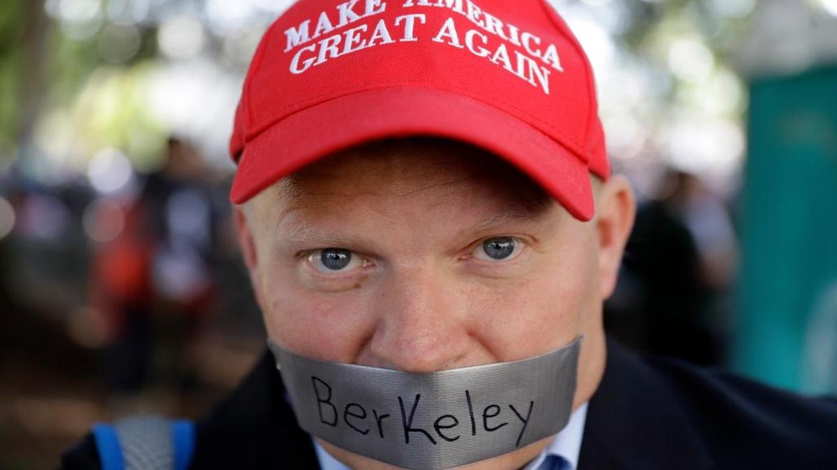 Daryl Tempesta tapes a sign over his mouth in protest during a demonstration Thursday, April 27, 2017, in Berkeley.