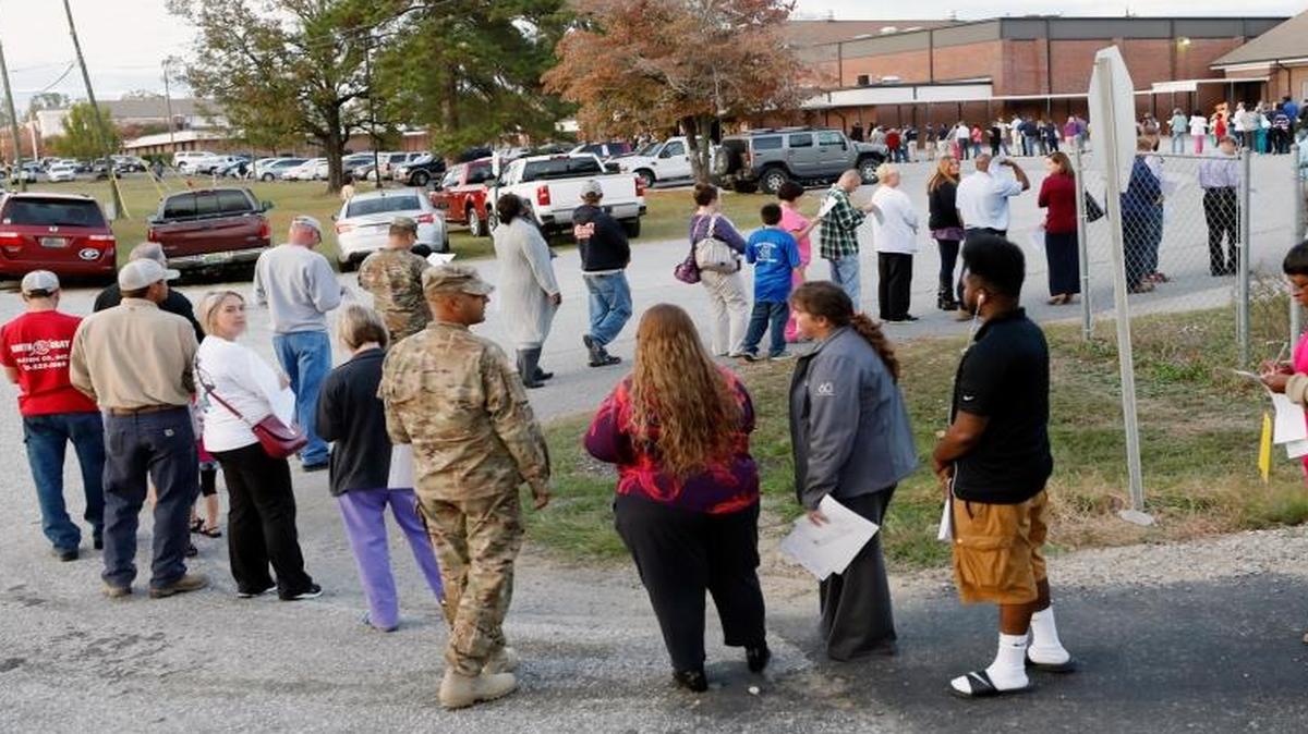 People stand in a long line to vote at the Smiths Station Junior High polling place in Smiths Station, Ala., on Tuesday.