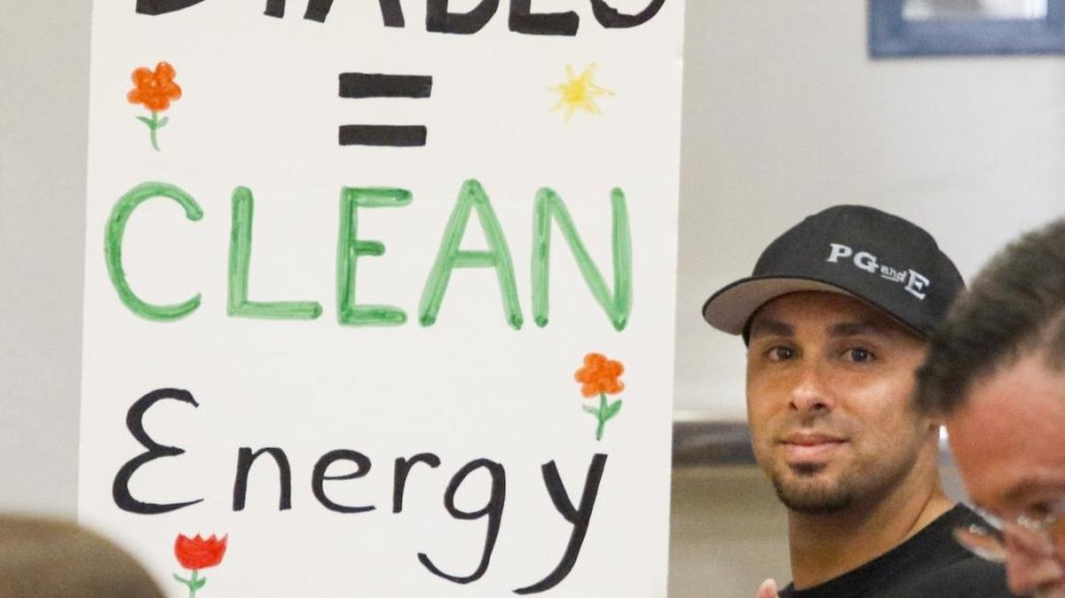 Albert Contreras holds a placard at a State Lands Commission hearing in Morro Bay in June 2016. The satellite hearing included lease renewal for Diablo Canyon nuclear power plant.