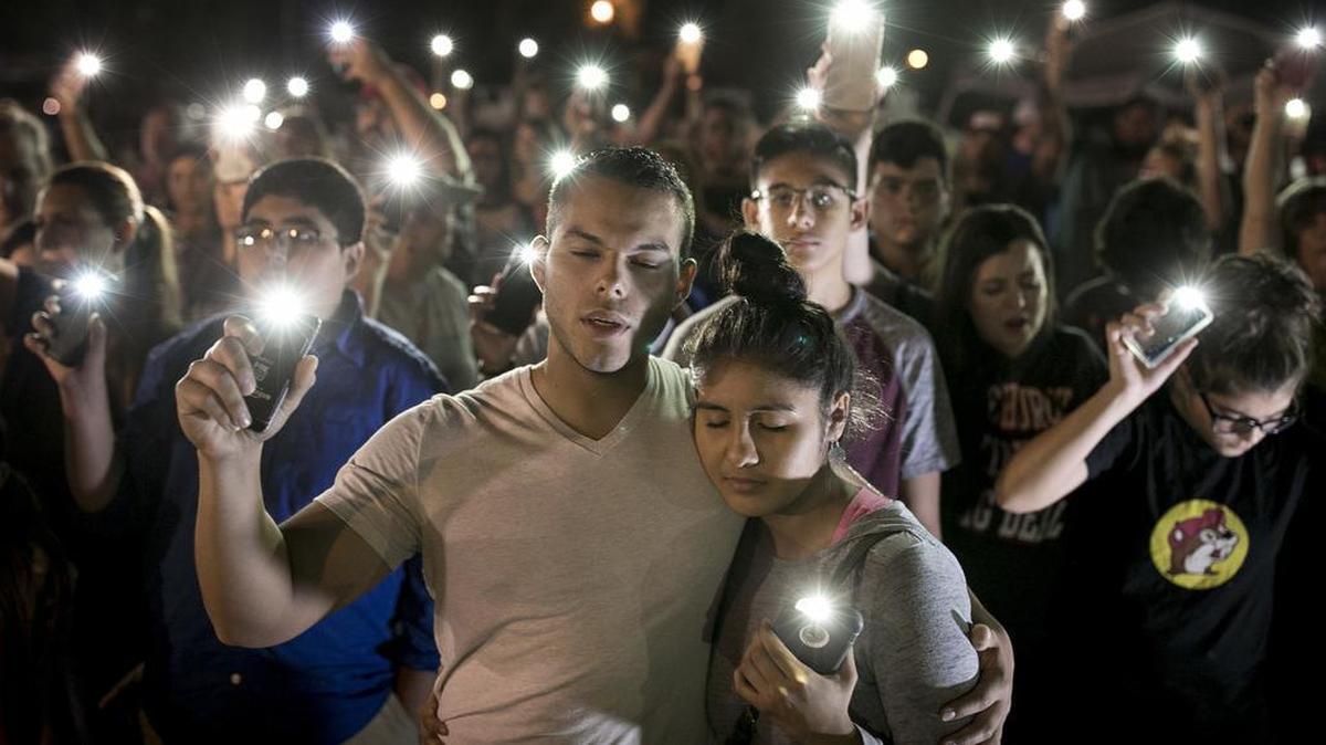 Matthew Mata and Erika Gonzalez participate in a memorial service for the victims of Sunday's church shooting in Sutherland Springs, Texas, on Monday, Nov. 6, 2017. The suspected gunman had a history of domestic violence and sent threatening text messages to his mother-in-law, a member of the church, before the attack in which he fired at least 450 rounds at helpless worshippers, authorities said Monday.